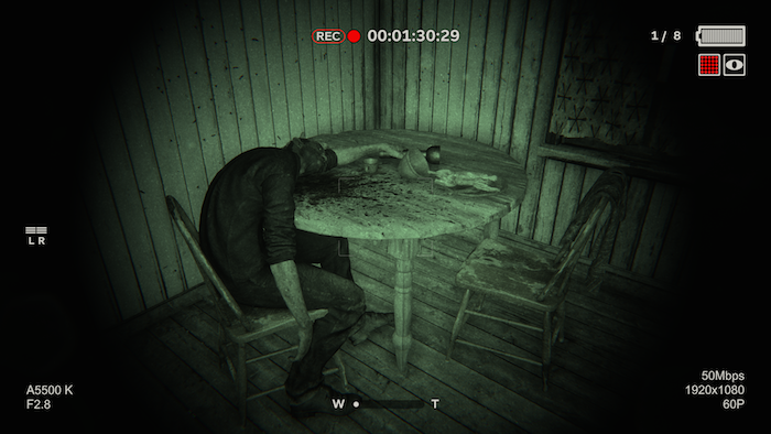 Une capture d'écran d'Outlast 2. Un corps est affalé sur une table.
