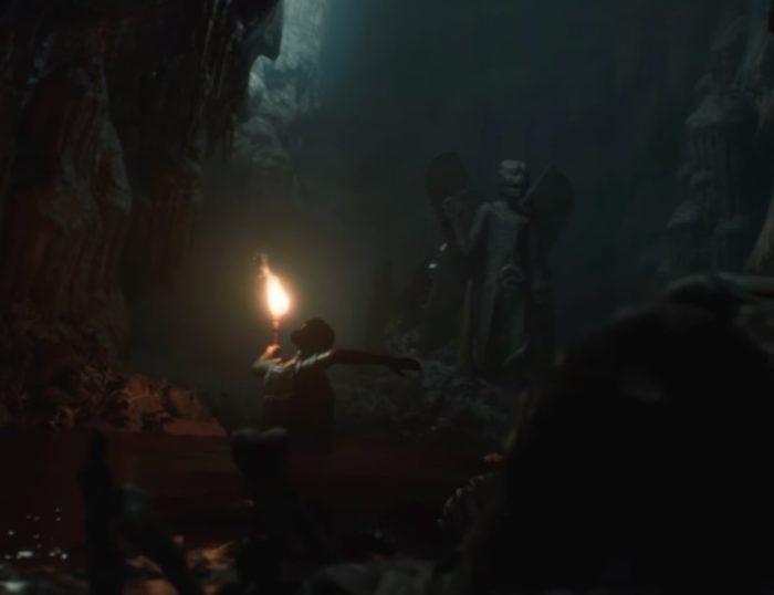 Une capture d'écran d'un personnage errant dans une tombe souterraine avec une torche de House of Ashes.
