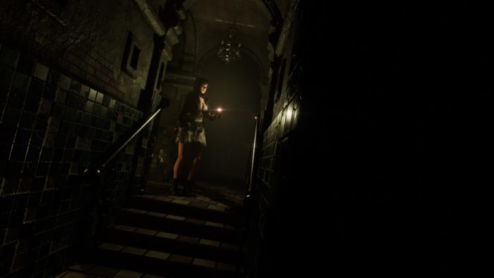 La protagoniste de Tormented Souls, Caroline Walker, debout en haut de certains escaliers, tenant un briquet.