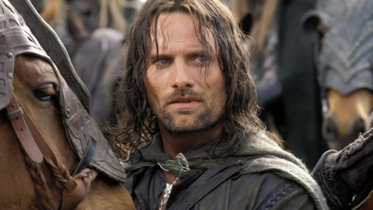 Une image montrant Viggo Mortensen dans le rôle d'Aragorn dans Le Seigneur des Anneaux : Les Deux Tours dans le cadre d'un article sur les anecdotes les plus folles de la production de la trilogie.  L'image montre Aragorn regardant hors de l'écran vers la droite et debout à côté d'un très beau cheval.