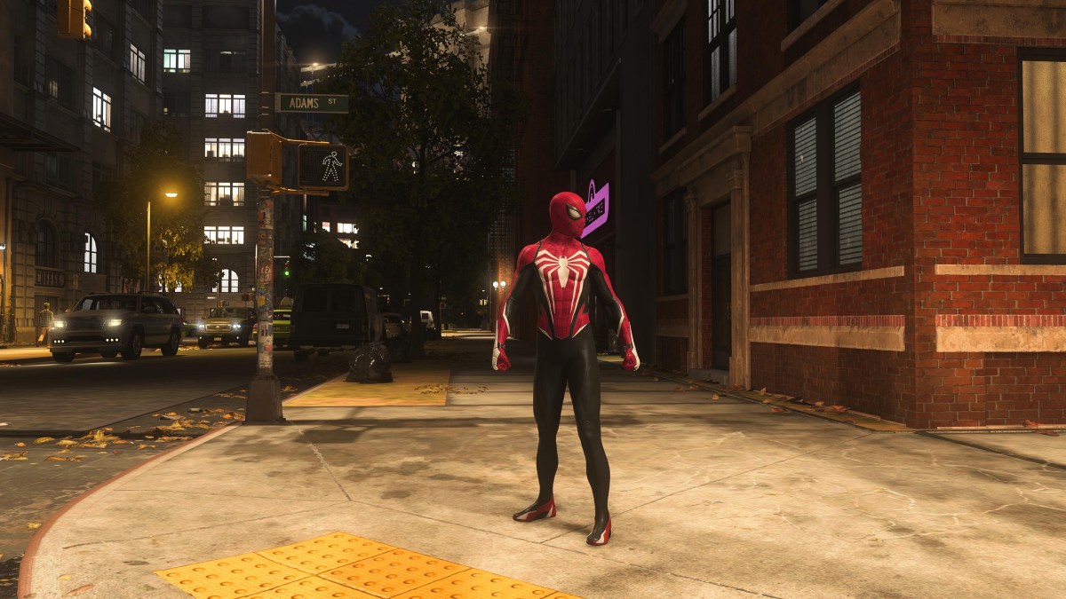 Une image montrant Peter Parker debout sur un trottoir à New York dans Marvel's Spider-Man 2 dans le cadre d'un guide expliquant comment débloquer toutes les combinaisons pour lui dans le jeu.