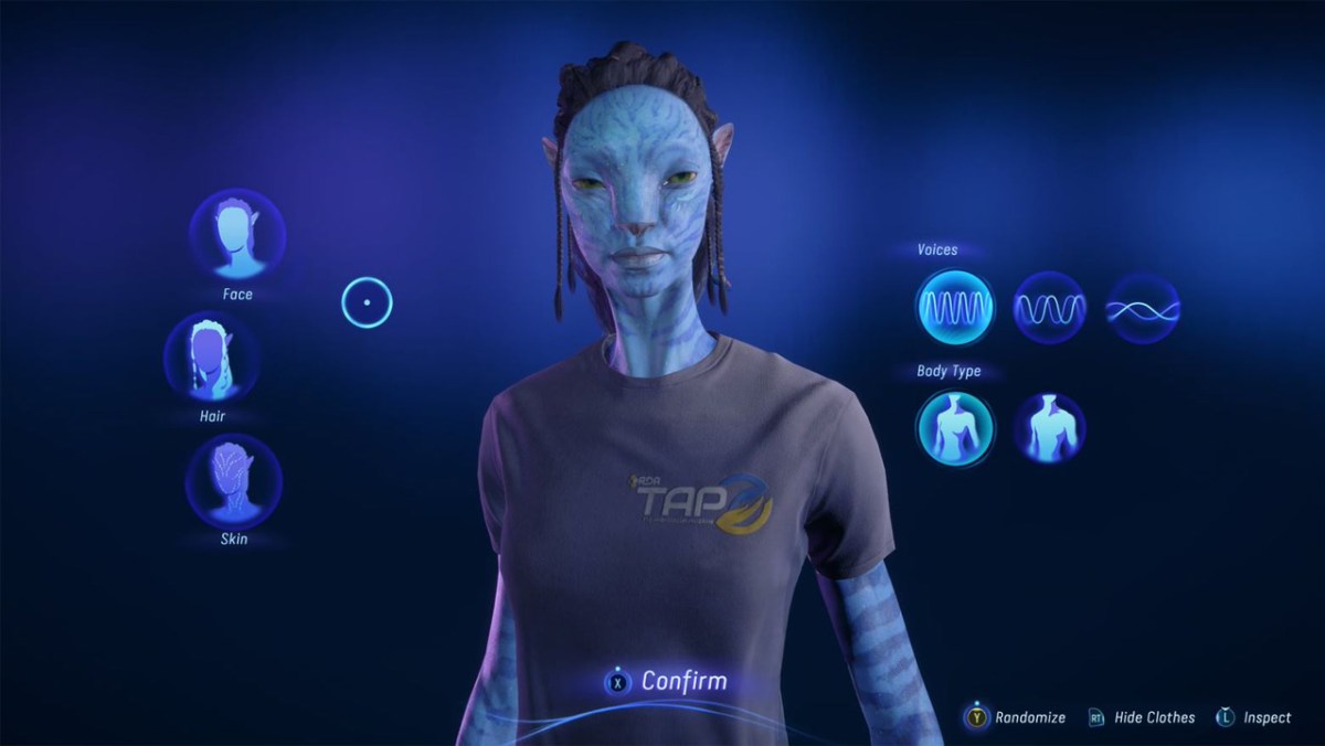 Une femme Na'vi portant un t-shirt « TAP ».  Il y a des boutons autour de son visage, de ses cheveux, de sa peau, de son corps et de ses voix marqués. 